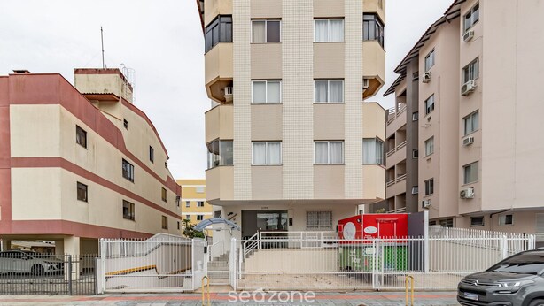 A multi-story building with a gated entrance, a clock, and a signboard. - Apartment 260 m From Canavieiras Beach Rrb0202 (Florianópolis)