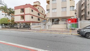 A multi-story building with a flat facade, a gated entrance, and a parked car. - Apartment 260 m From Canavieiras Beach Rrb0202 (Florianópolis)