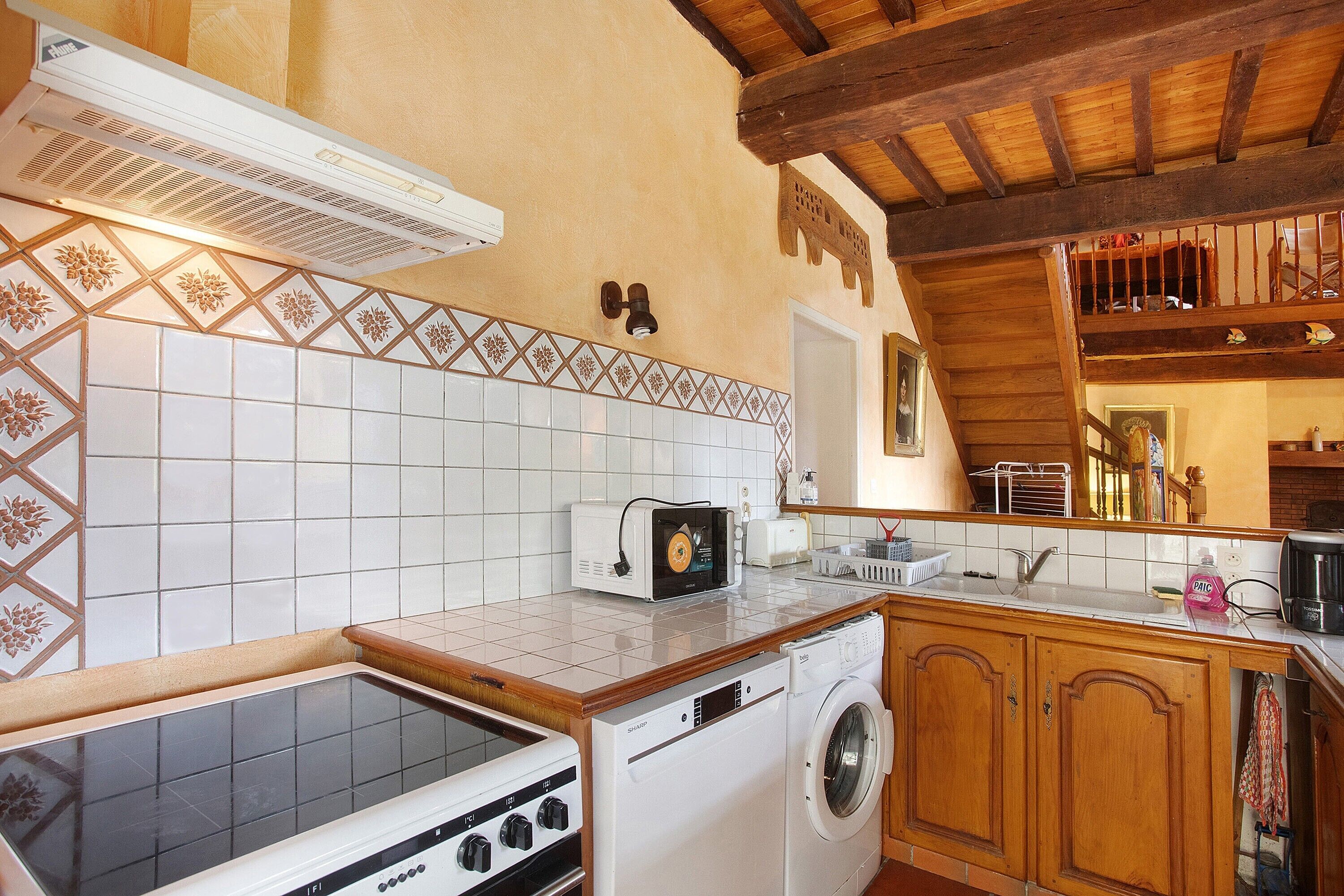 A kitchen with a stove, microwave, and washing machine.