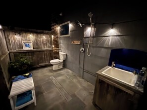 Un baño pequeño con inodoro, ducha y lavamanos.