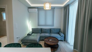 Una sala de estar moderna con un sofá modular, una mesa redonda de centro y una lámpara colgante.