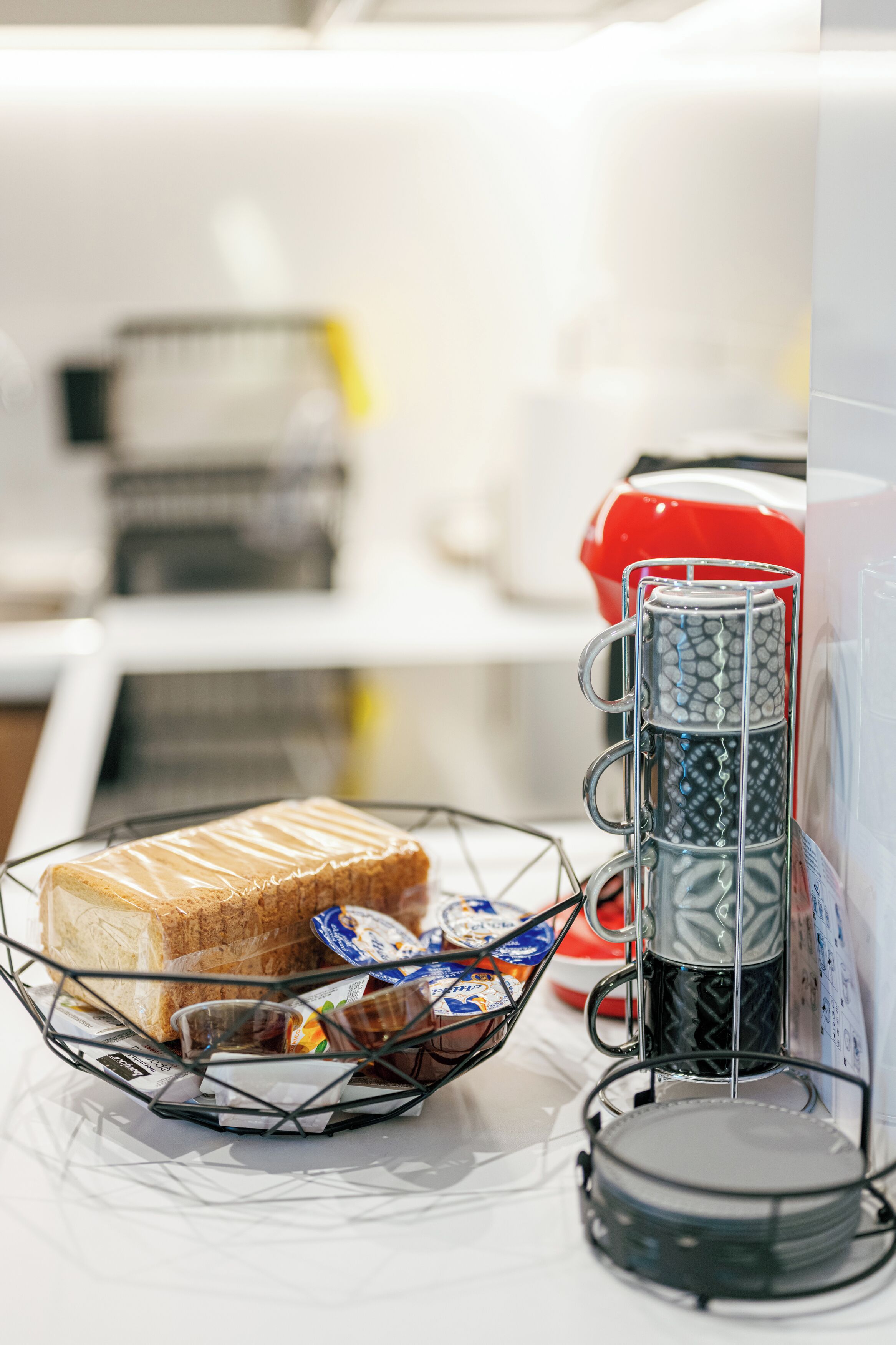 Un bar pour le petit-déjeuner avec un panier à pain, un porte-tasses et une machine à café.