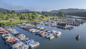 A marina with numerous boats docked, surrounded by greenery and hills. - Queen Lodge | 2 Beds + Pet | No Hidden Fees (Roanoke)