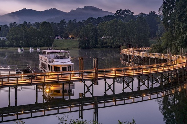 Twilight settles over the marina as lights reflect on the lake, setting a magical tone for the evening.