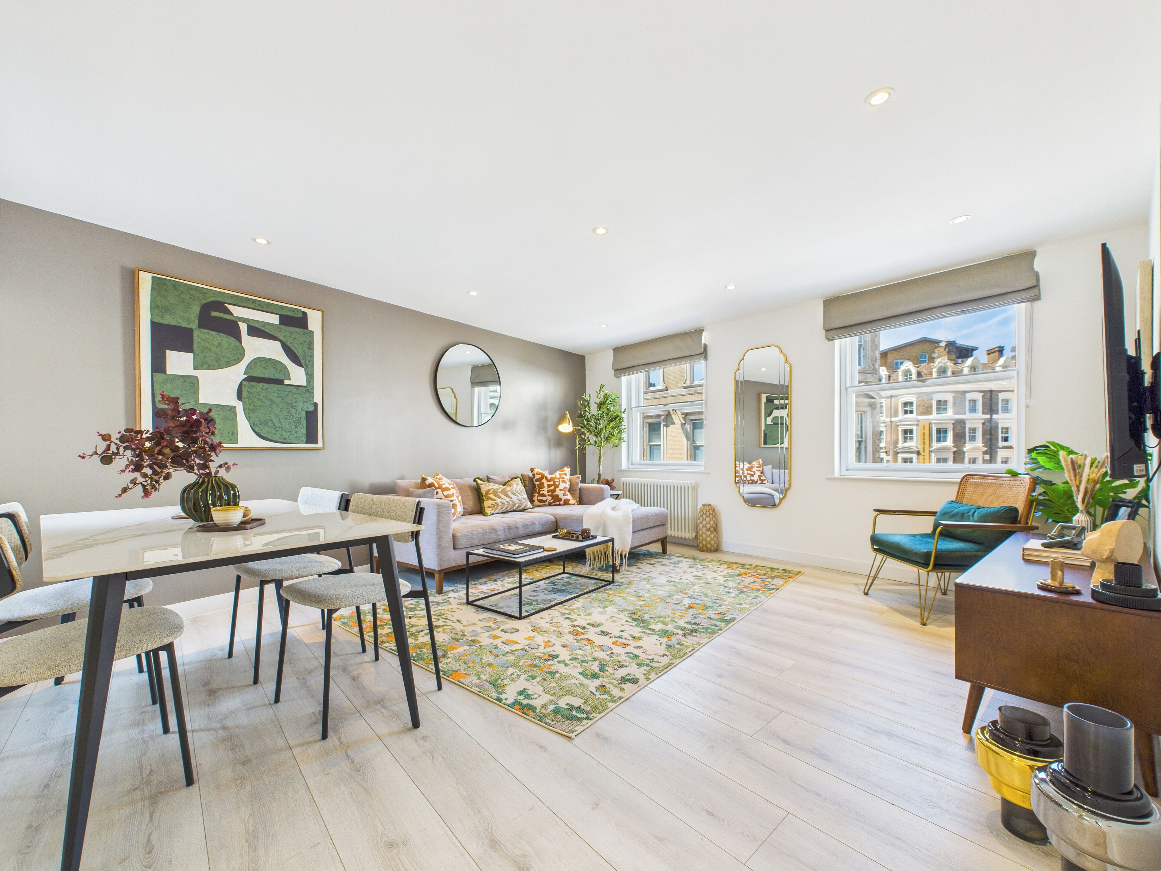 Een moderne woonkamer met een bank, salontafel en een eethoek.