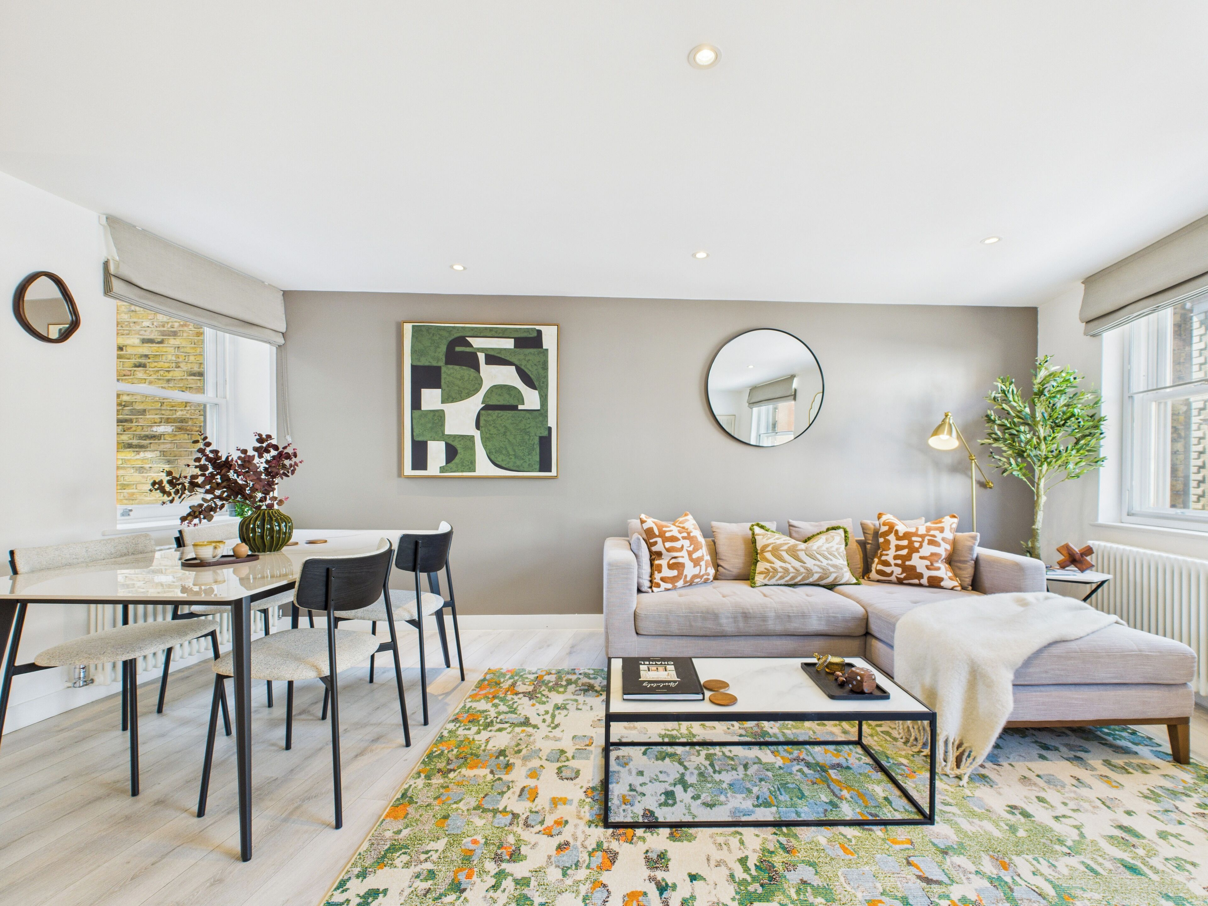 A modern living room with a sofa, coffee table, and dining area.