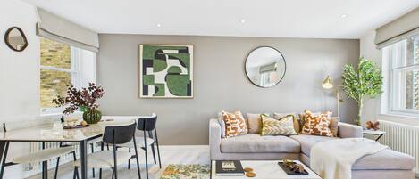 A modern living room with a sofa, coffee table, and dining area.