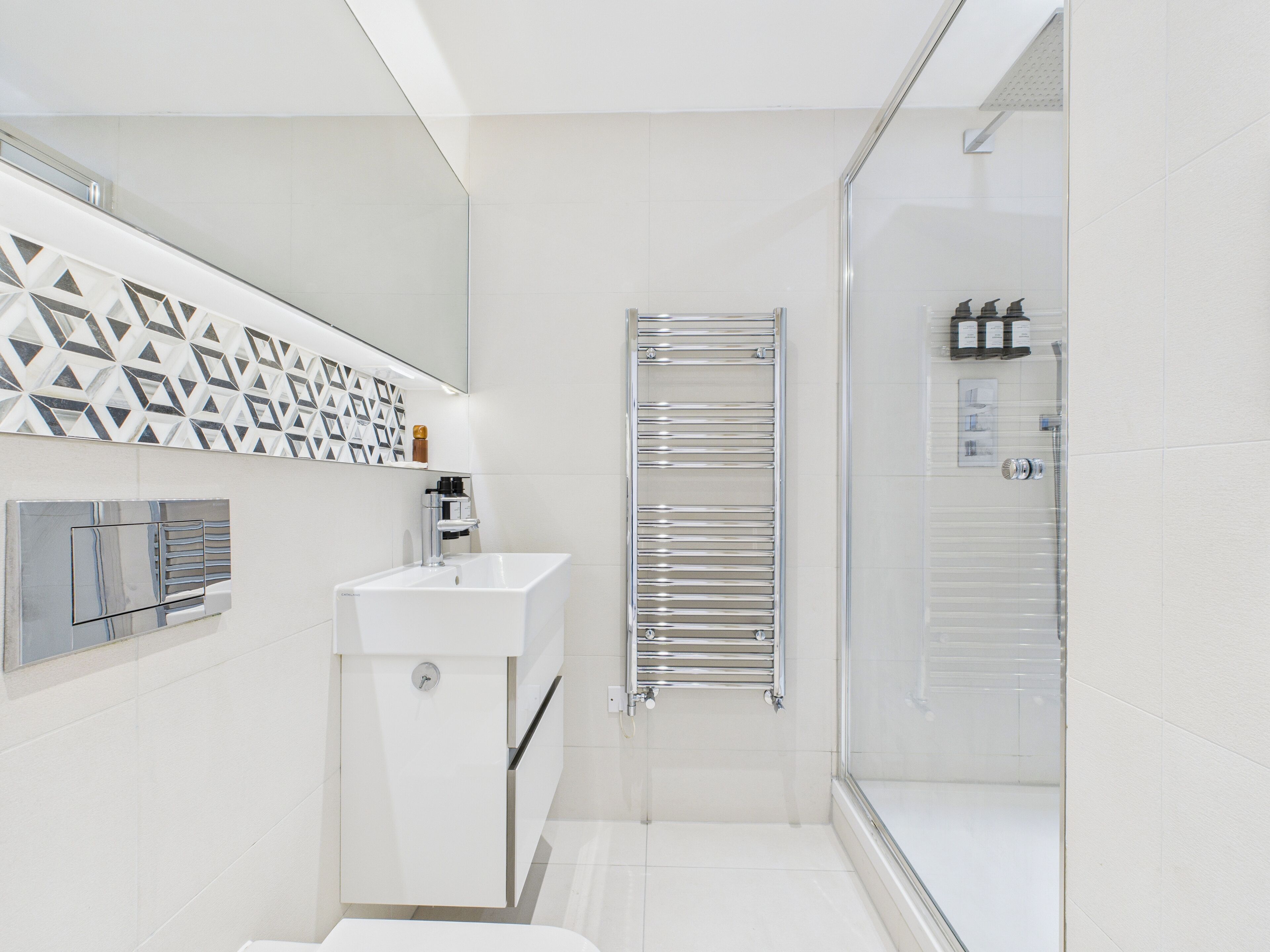 Ein modernes Badezimmer mit Dusche, Waschbecken und Toilette.