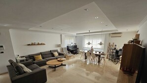 A modern living room with a sofa, coffee table, and dining area.