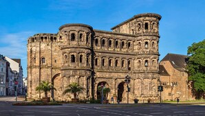 Um edifício histórico de pedra com arcadas e uma torre de sino.