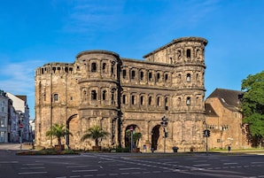 A historic stone building with arched doorways and a bell tower.