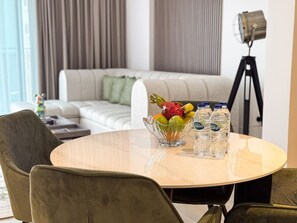 A modern living room with a round table, a sofa, and a floor lamp.