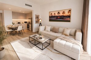A modern living room with a sofa, coffee table, and dining area.