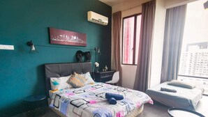 Ein Schlafzimmer mit Bett, Schreibtisch, Stuhl und einem Fenster mit Vorhängen.