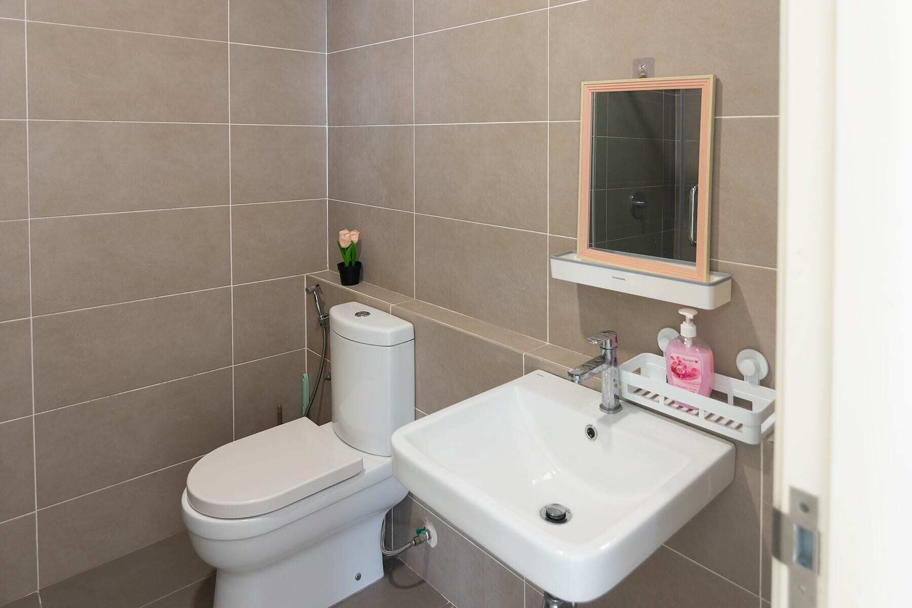 Un baño con inodoro, lavamanos y espejo.