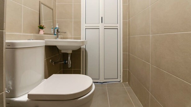 Un baño pequeño con inodoro, lavamanos y espejo.