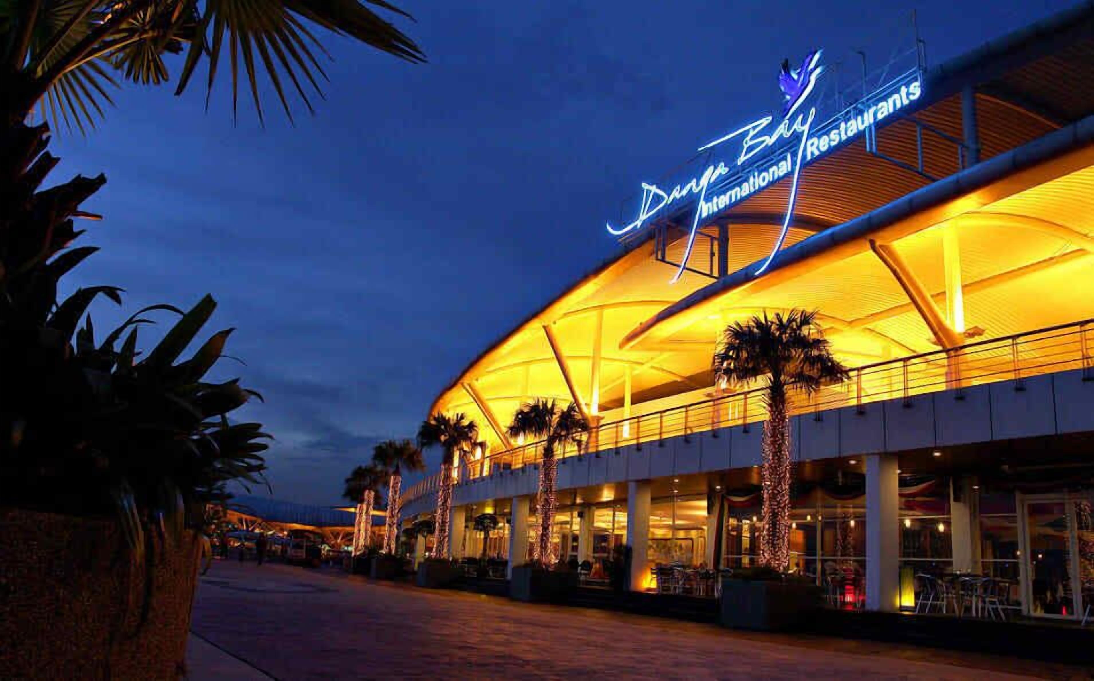 A large, modern building with a curved roof and a prominent sign reading "Dora's Bay International Restaurant."
