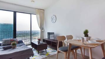 A modern living room with a sofa, coffee table, and dining area with chairs and a table.