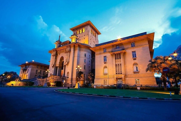 A large, historic building with classical architecture, featuring a prominent tower and arched windows.