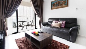 A modern living room with a black leather sofa, a coffee table, and a painting on the wall. - High-floor 2BR Suite, Water Views, Free Parking (Johor Bahru)