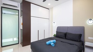 Ein modernes Schlafzimmer mit einem großen Bett, einem Kleiderschrank und einem Deckenventilator.