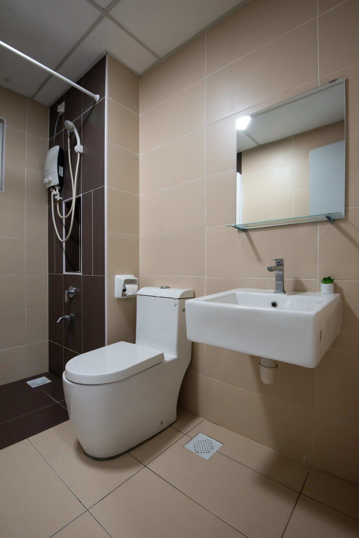 Een moderne badkamer met toilet, douche en wastafel.