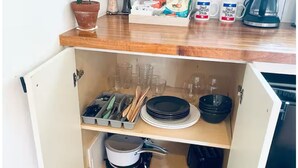 A kitchen with a wooden countertop, a potted plant, a coffee maker, and a cabinet with dishes and utensils. - H-Town Golden Bird Chic Lg Studio 10 the Best of Montrose (Houston)