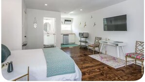 A bedroom with a bed, a desk, and a TV. - H-Town Golden Bird Chic Lg Studio 10 the Best of Montrose (Houston)
