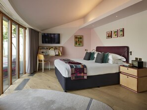 Ein modernes Schlafzimmer mit einem großen Bett, einem Schreibtisch und einem Fernseher.
