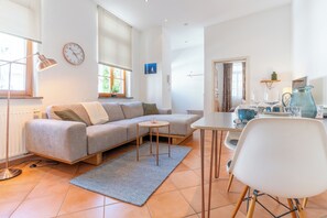 Uma sala de estar moderna com sofá, mesa de centro e mesa de jantar.