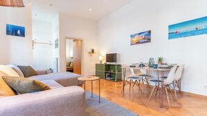 A modern living room with a sofa, a dining table with chairs, and artwork on the walls. - Copper House - Old Town Constance (Konstanz)