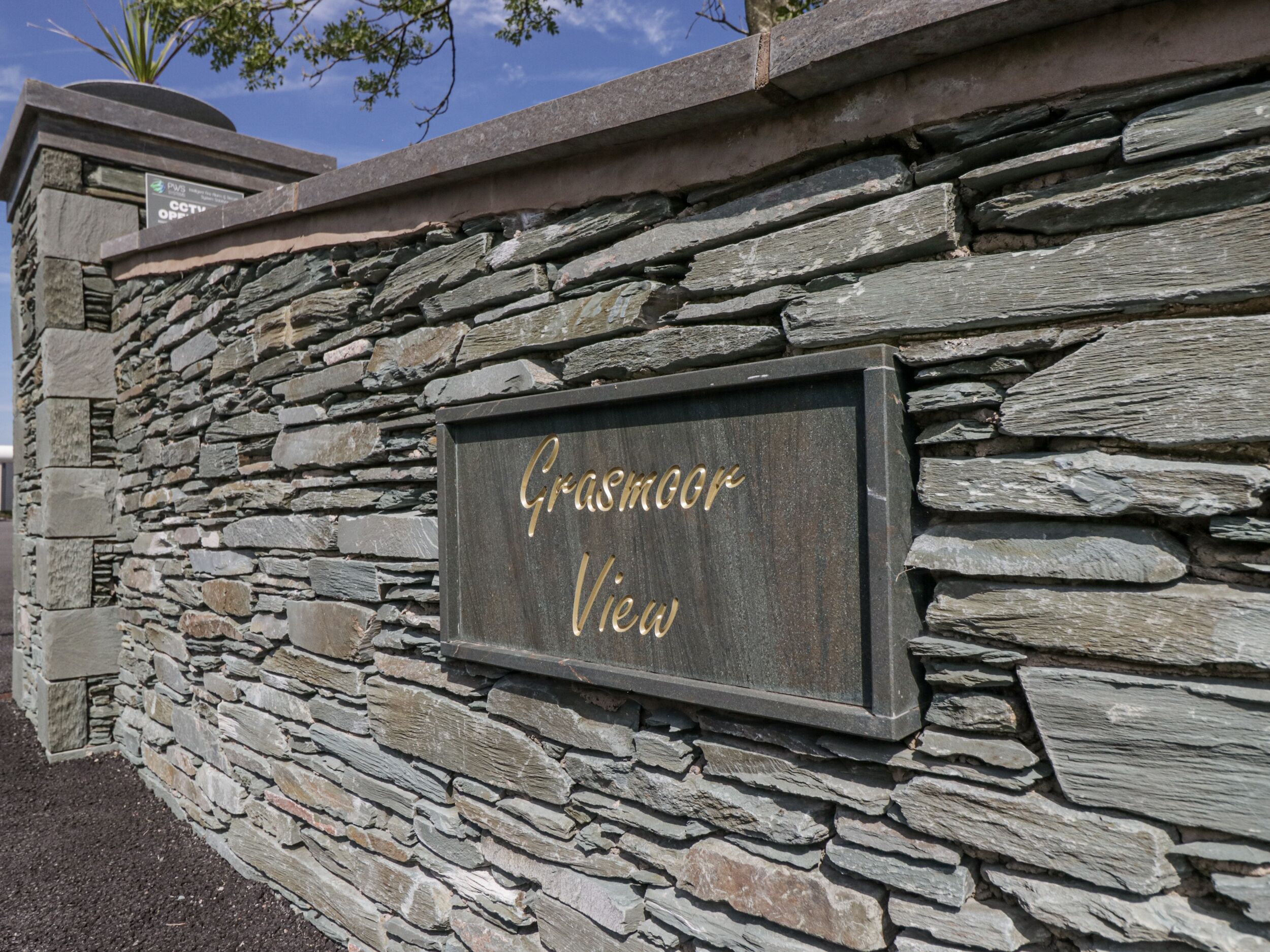 Eine Steinmauer mit einem Schild, auf dem 'Grasmere View' steht.