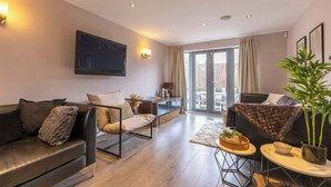Una sala de estar moderna con un sofá, un sillón y un comedor con mesa y sillas.