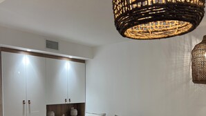 A modern living room with a sectional sofa, a laptop on a table, and a wicker pendant light. - CANET SUD PANORAMIC SEA VIEW EXCEPTIONAL APARTMENT (Canet-en-Roussillon)