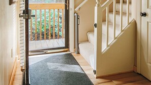 Una escalera con barandilla de madera y un rellano alfombrado.