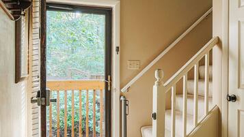 A staircase with a wooden handrail and a carpeted landing.