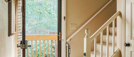 A staircase with a wooden handrail and a carpeted landing.