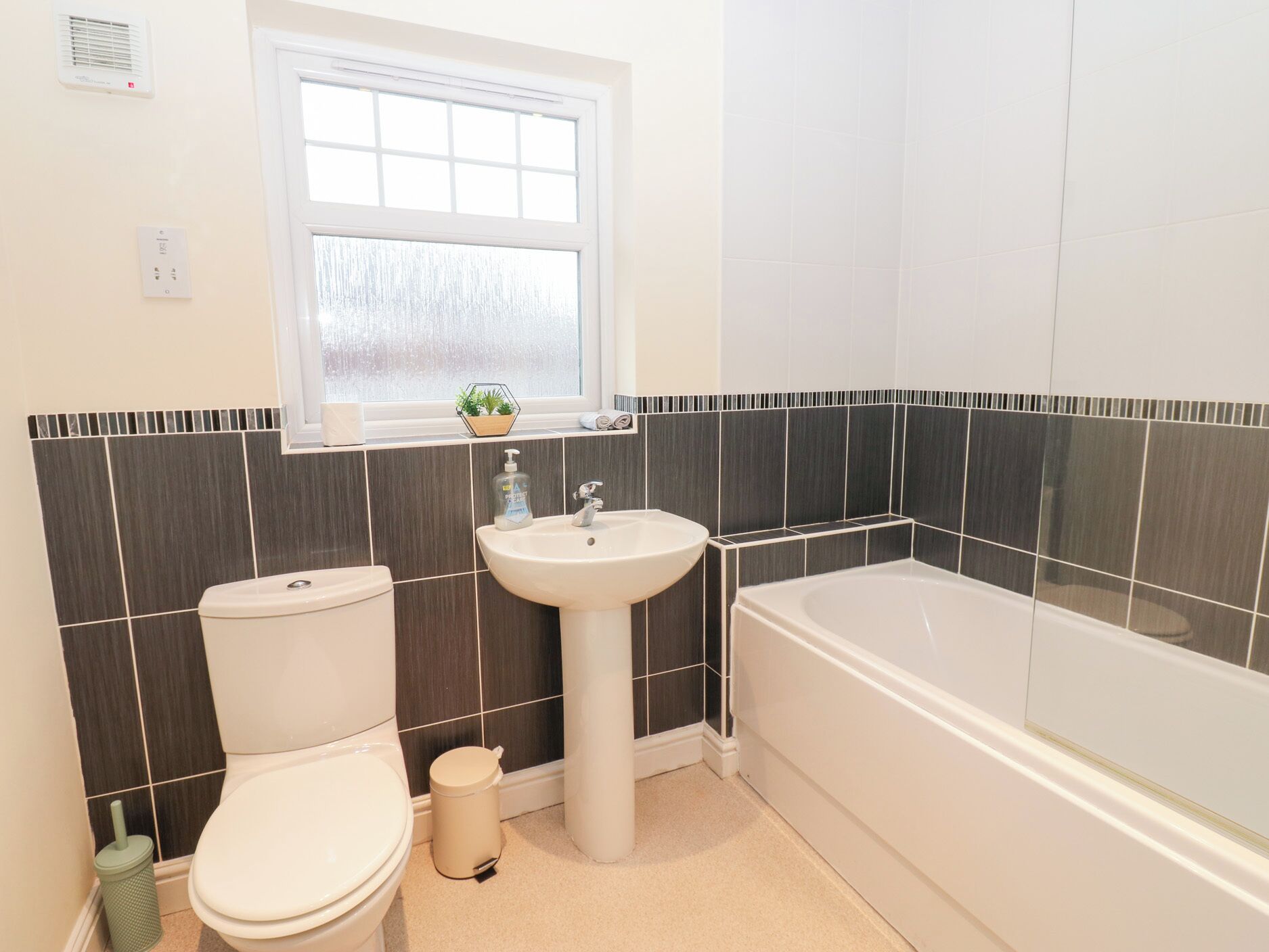 A bathroom with a toilet, sink, and bathtub.