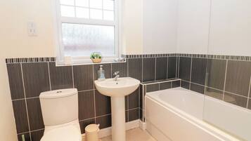 A bathroom with a toilet, sink, and bathtub.
