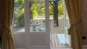 Et soveværelse med en stor skydedør, der fører ud til en terrasse.