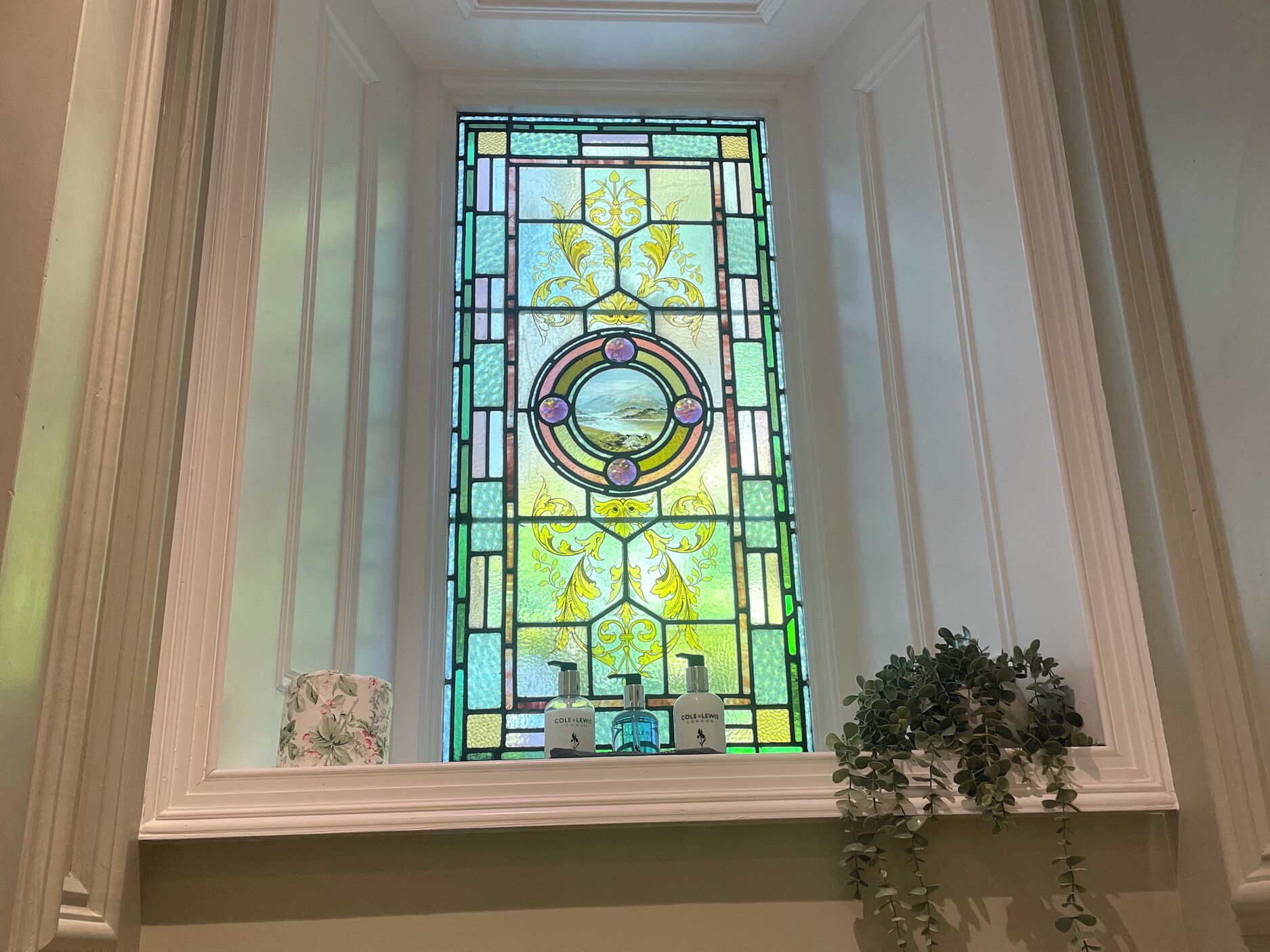 A stained glass window with geometric patterns and a central circular design.