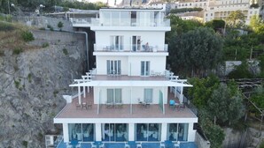 Un immeuble à plusieurs étages doté d’une terrasse et d’un espace repas.