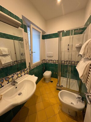 Habitación estándar doble | Baño | Ducha, secador de pelo, toallas y jabón
