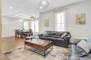 Una sala moderna con sofá, mesa de centro y comedor.