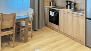 A compact kitchen with wooden cabinets, a microwave, a coffee maker, and a sink. - Riverside Apartment 11 (Hlavní město Praha)
