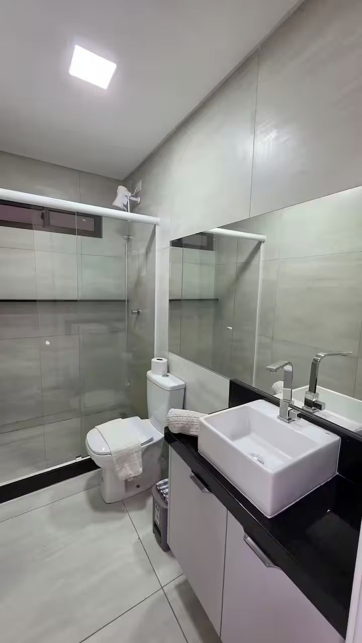 Un bagno moderno con servizi igienici, lavabo e zona doccia.