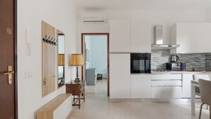 Une cuisine moderne avec des armoires blanches, un four encastré et une cuisinière à gaz.
