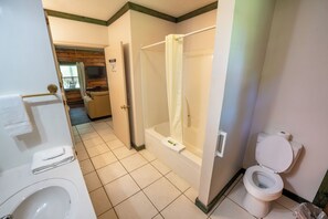 A bathroom with a bathtub, toilet, and shower. - Fishtale Lodge (Buchanan)