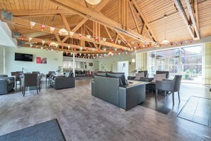 Un vestíbulo espacioso con techos altos, muebles modernos y grandes ventanales.