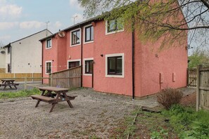 Un bâtiment rouge avec de nombreuses fenêtres et une clôture en bois.